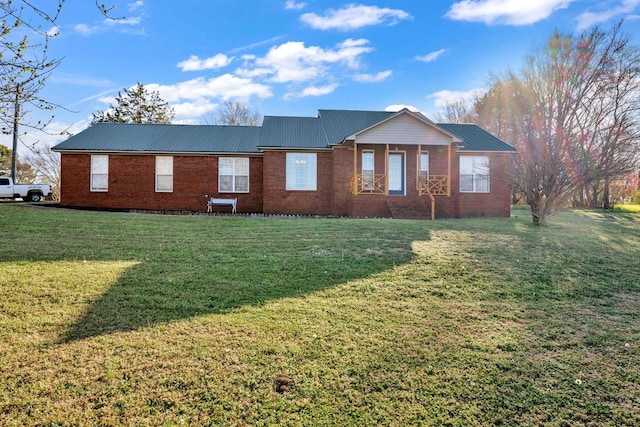 - ranch-style home featuring a front yard, brick siding, and a metal roof