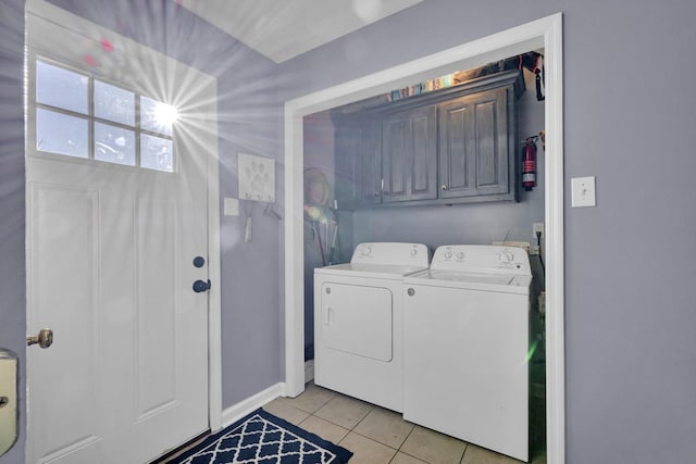  - washroom featuring washing machine and dryer, cabinet space, and light tile patterned flooring