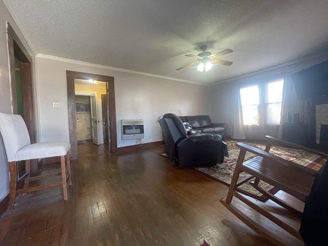 living room with heating unit, ornamental molding, dark hardwood / wood-style flooring, and a brick fireplace