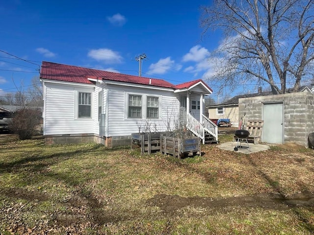 back of house with an outbuilding and a lawn