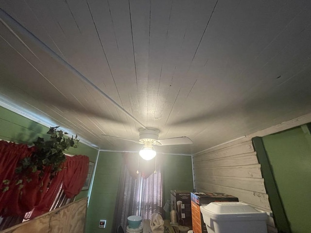 interior details with ceiling fan and wooden walls