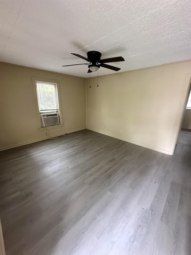 empty room featuring hardwood / wood-style floors, a textured ceiling, ceiling fan, and cooling unit