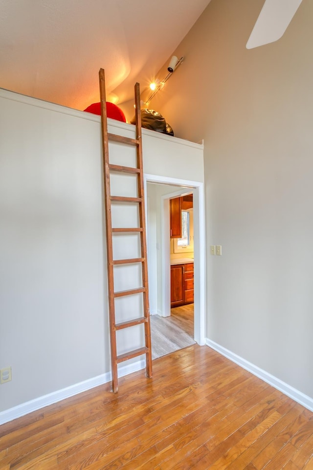 empty room with vaulted ceiling and light wood-type flooring