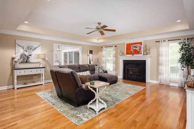  - living room featuring hardwood / wood-style flooring, ceiling fan, a wealth of natural light, and a tray ceiling