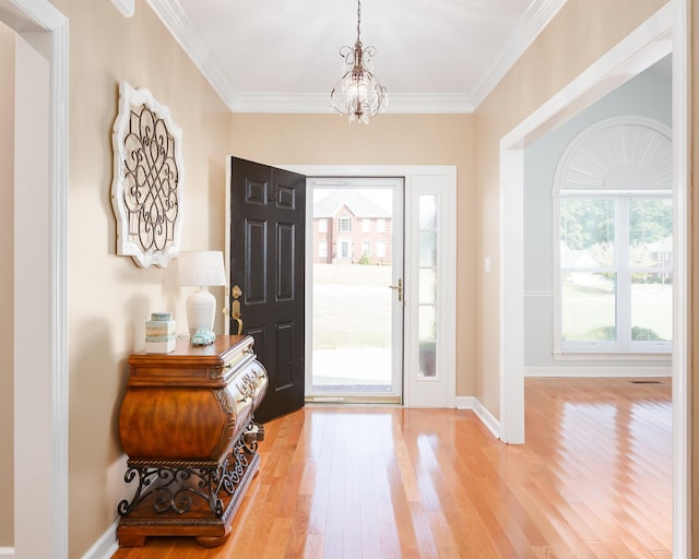 entryway featuring hardwood / wood-style floors, an inviting chandelier, and crown molding