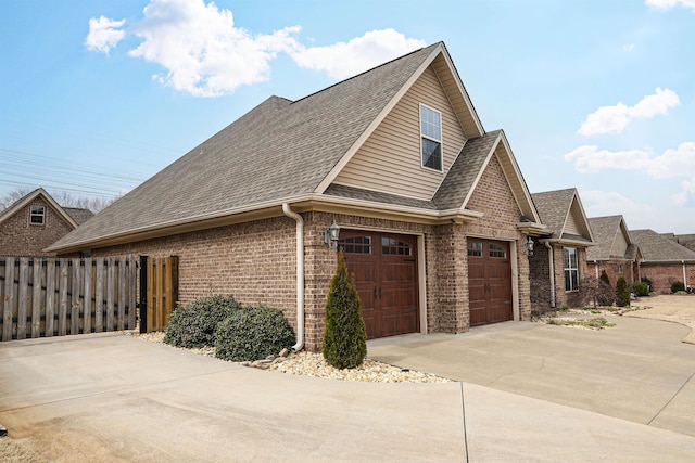 view of property exterior with brick siding, fence, concrete driveway, roof with shingles, and a garage