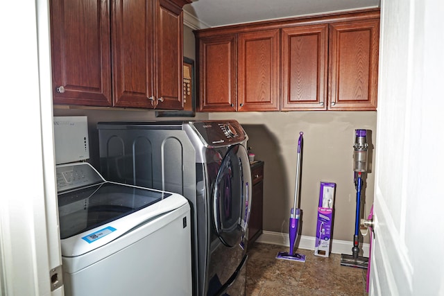 laundry room with cabinet space, separate washer and dryer, and baseboards