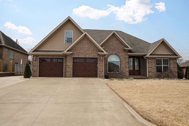 view of front of house featuring fence, brick siding, driveway, and a shingled roof