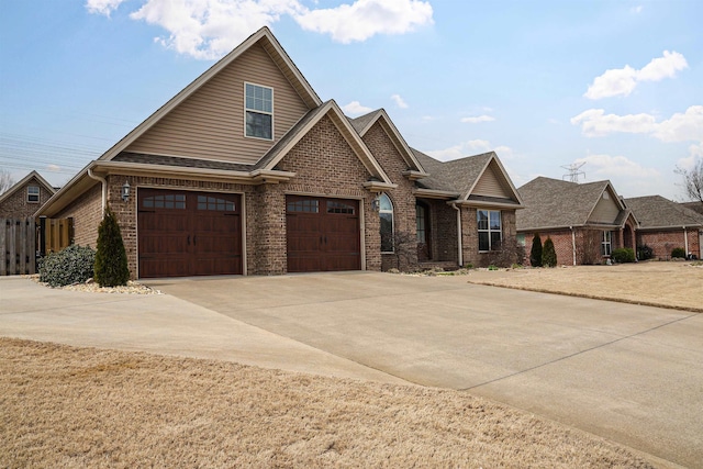 craftsman inspired home featuring a garage, brick siding, driveway, and roof with shingles