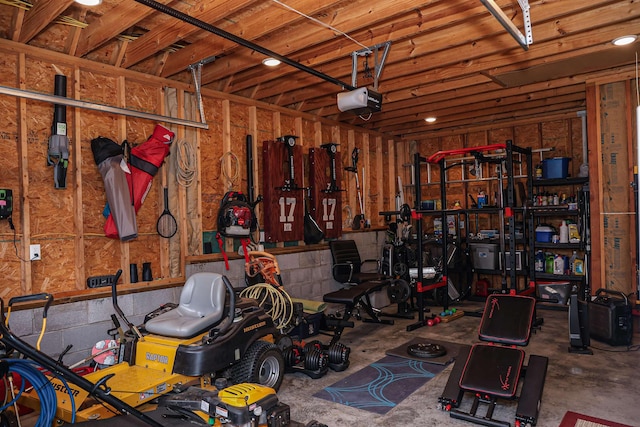 garage featuring concrete block wall and a garage door opener