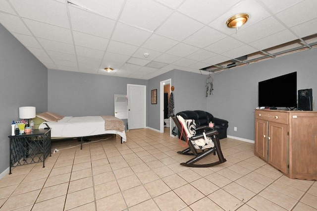 bedroom featuring a drop ceiling and light tile patterned flooring