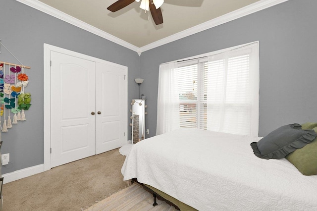 bedroom with ceiling fan, crown molding, light carpet, and a closet