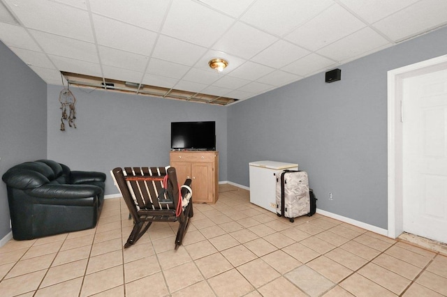 sitting room with a paneled ceiling and light tile patterned flooring