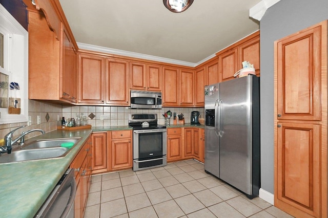 kitchen featuring sink, light tile patterned flooring, ornamental molding, and appliances with stainless steel finishes