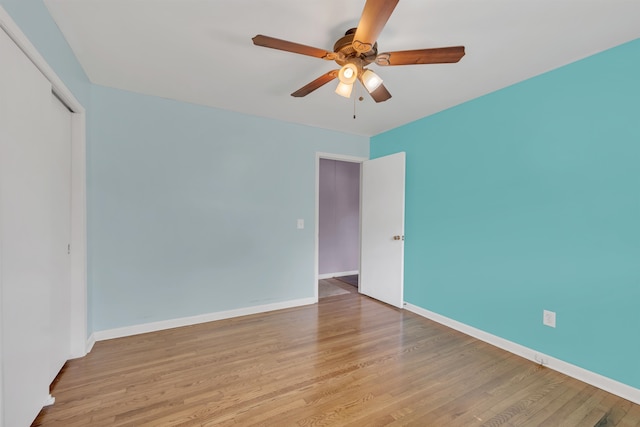  - empty room with ceiling fan, wood finished floors, and baseboards