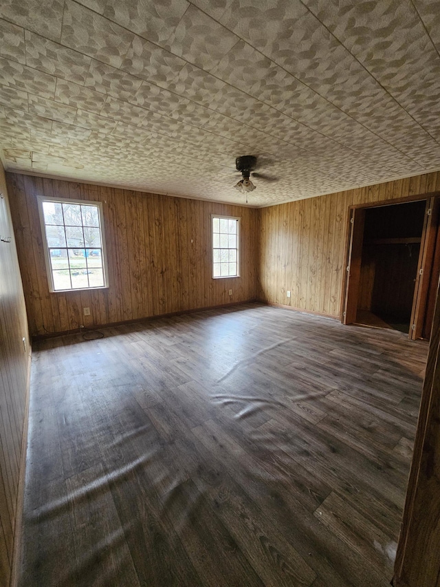 spare room featuring wooden walls and dark hardwood / wood-style floors