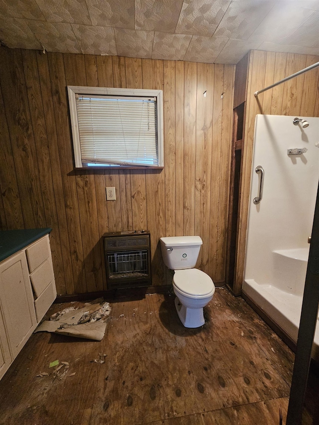 bathroom featuring heating unit, vanity, toilet, and walk in shower