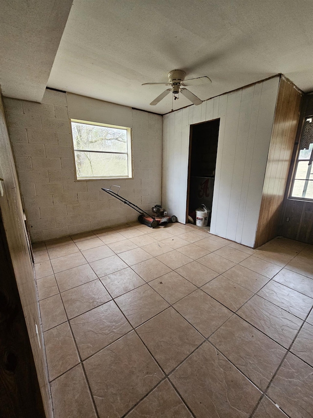 tiled spare room featuring a textured ceiling and ceiling fan