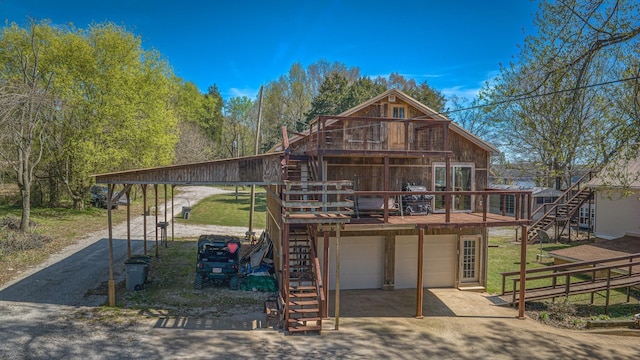 back of house with a yard, a garage, a carport, and a wooden deck