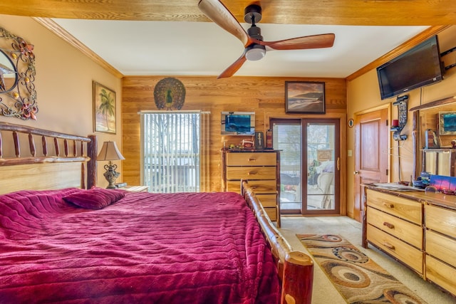 carpeted bedroom featuring access to exterior, crown molding, ceiling fan, and wooden walls