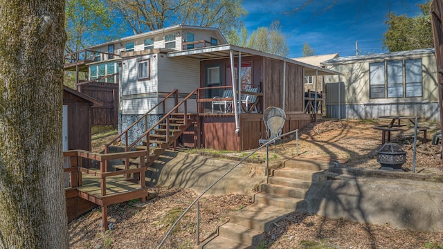 rear view of property with an outdoor fire pit