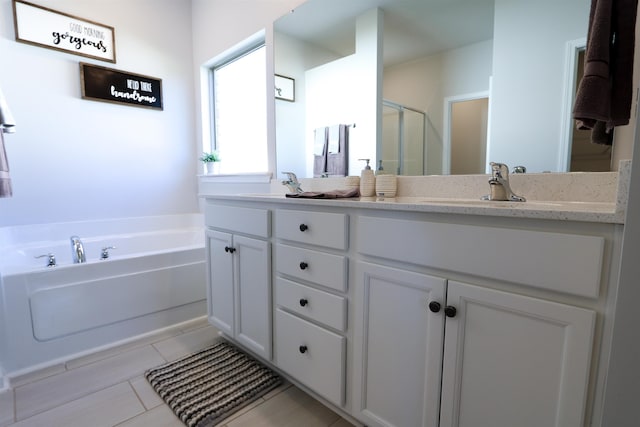 full bath featuring double vanity, a bath, a sink, and tile patterned floors