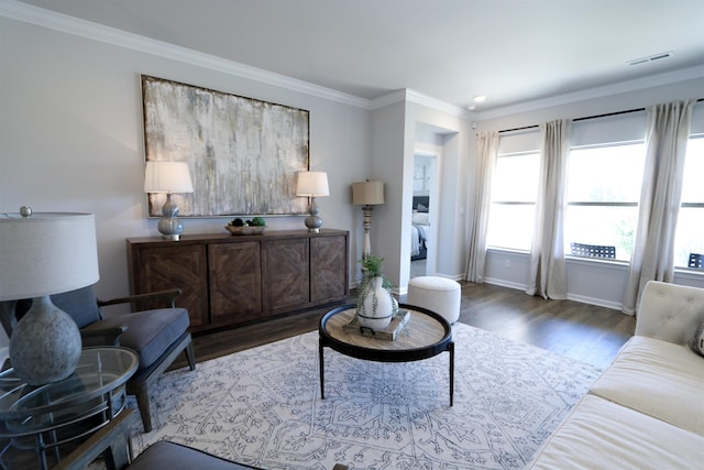 living room with ornamental molding, wood finished floors, visible vents, and baseboards