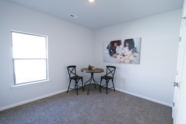 carpeted dining room featuring visible vents and baseboards