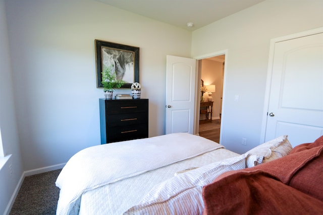 bedroom with dark carpet and baseboards