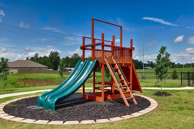 community jungle gym with a yard and fence