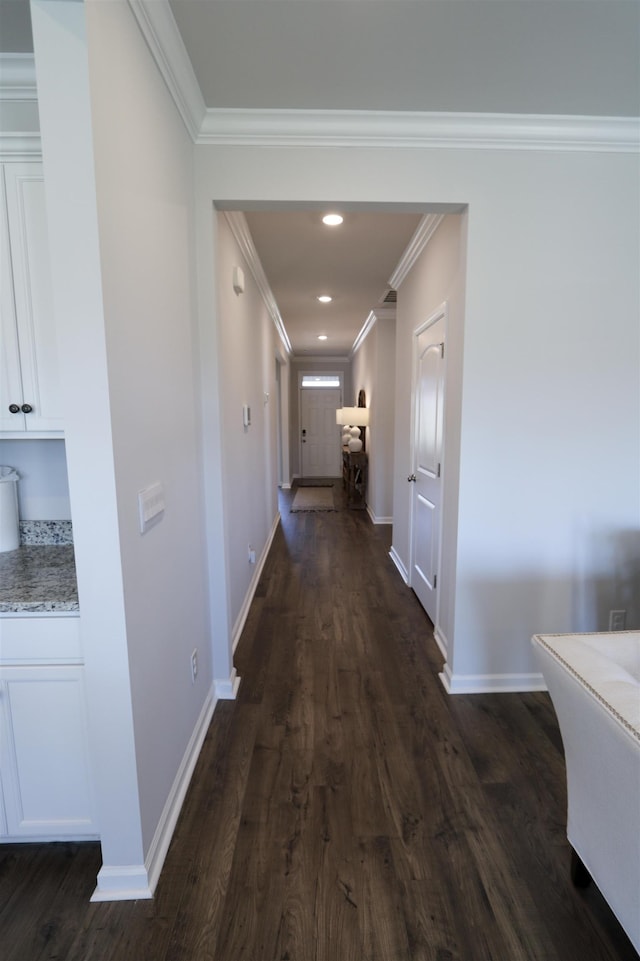 hall featuring baseboards, dark wood-style flooring, arched walkways, and crown molding