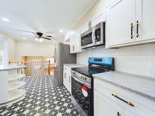 kitchen with ceiling fan, stainless steel appliances, light stone counters, crown molding, and white cabinets