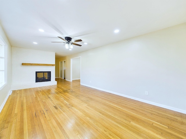 unfurnished living room featuring ceiling fan, light hardwood / wood-style floors, and a fireplace