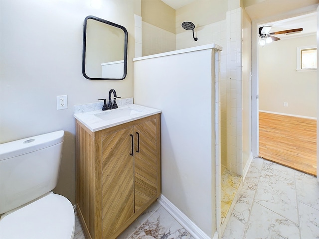 bathroom featuring ceiling fan, toilet, vanity, and walk in shower