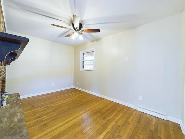 unfurnished room featuring hardwood / wood-style flooring, ceiling fan, and a baseboard heating unit