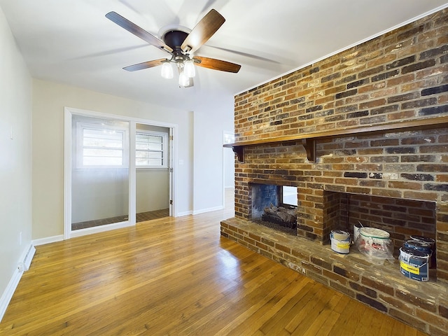 unfurnished living room with ceiling fan, a fireplace, and light hardwood / wood-style floors