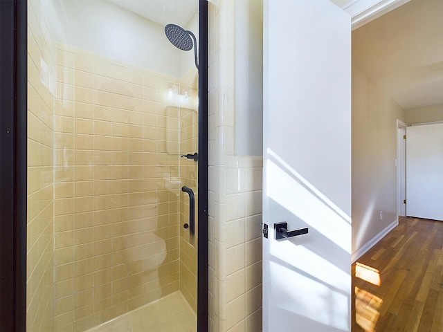 bathroom with hardwood / wood-style floors and tiled shower