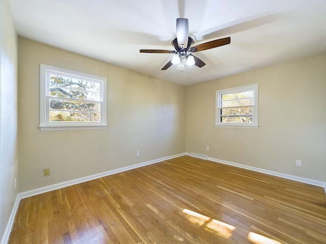 empty room with ceiling fan, a baseboard heating unit, and light hardwood / wood-style flooring