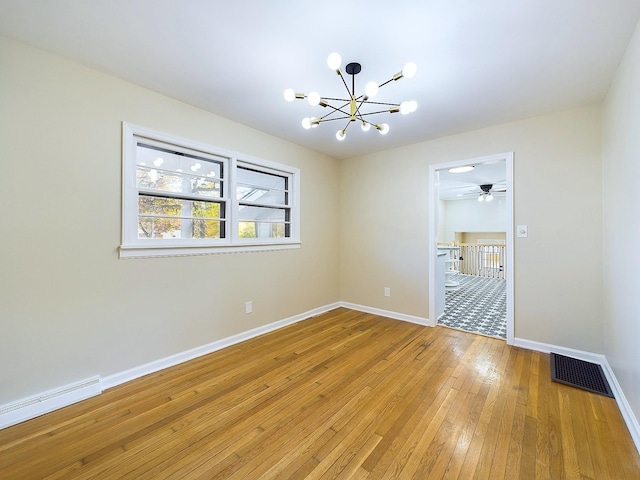 spare room with a baseboard radiator, a notable chandelier, and hardwood / wood-style flooring