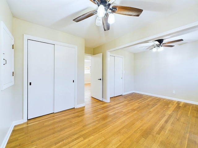 unfurnished bedroom with ceiling fan, electric panel, and light hardwood / wood-style flooring