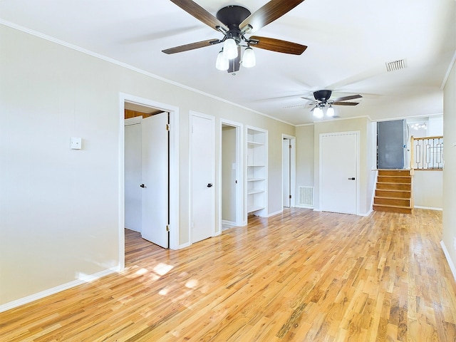 interior space featuring built in shelves, ceiling fan, light hardwood / wood-style floors, and ornamental molding