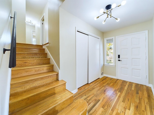 entryway with light wood-type flooring and an inviting chandelier