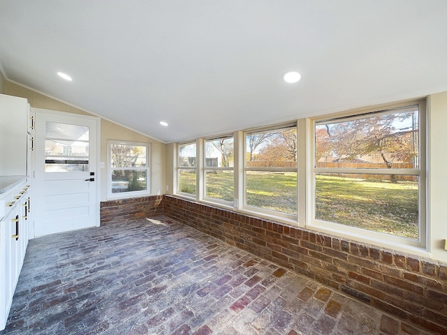 unfurnished sunroom featuring vaulted ceiling