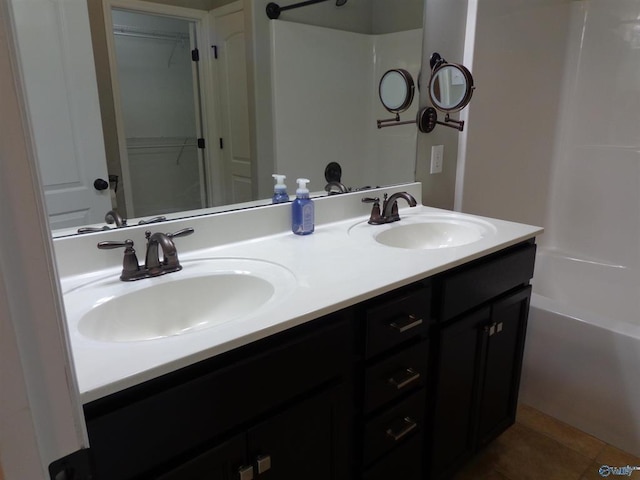  - bathroom featuring double vanity, shower / bath combination, tile patterned floors, and a sink