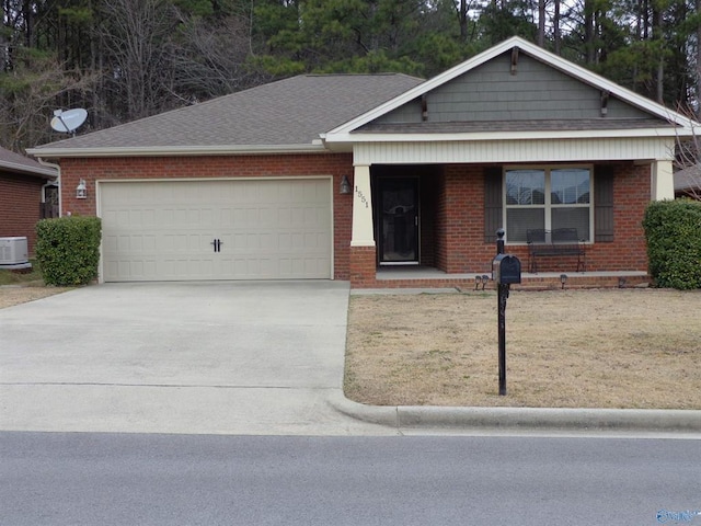 ranch-style house with a garage, brick siding, driveway, and roof with shingles