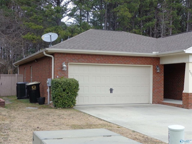 view of property exterior featuring concrete driveway, a shingled roof, a garage, brick siding, and central AC unit