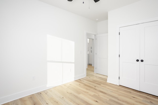 unfurnished bedroom featuring light hardwood / wood-style flooring, a closet, and ceiling fan