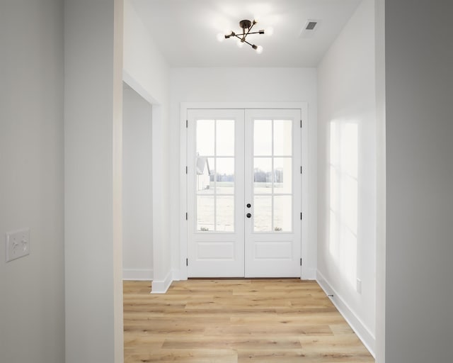 doorway with light hardwood / wood-style flooring and french doors