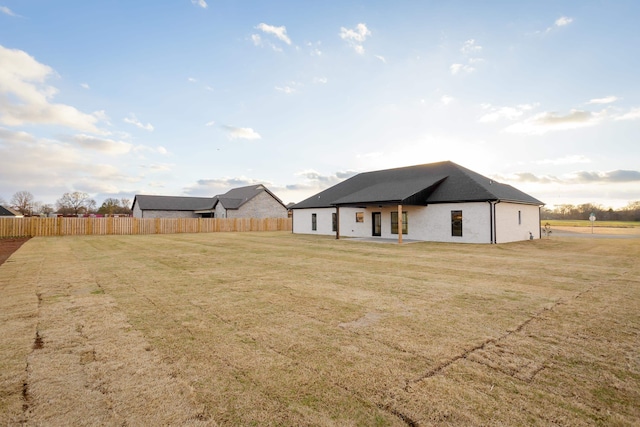 rear view of house featuring a lawn