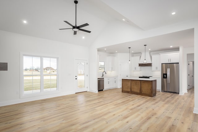 kitchen featuring white cabinetry, hanging light fixtures, light wood-type flooring, appliances with stainless steel finishes, and a large island